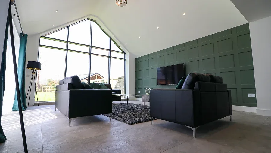 How to layer lighting in a luxury living room using a statement pendant, floor lamp and recessed downlights